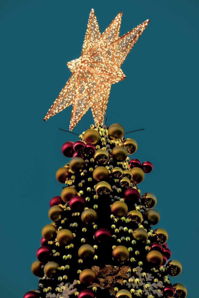 A festive Christmas tree adorned with a glowing star and colorful ornaments.